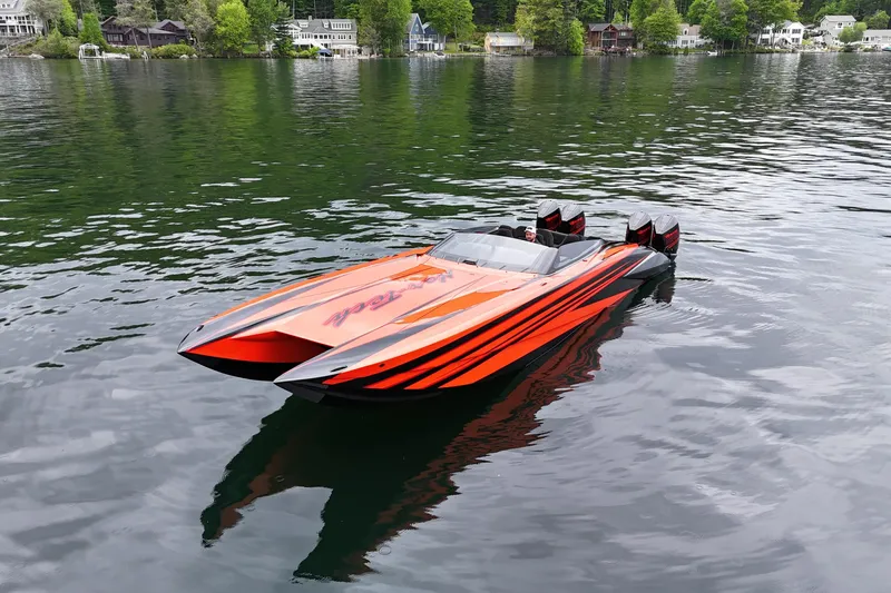 Slide: The Image of 2027 Nor-Tech 4000 Roadster speedboat with vibrant orange design on a serene lake. - 4