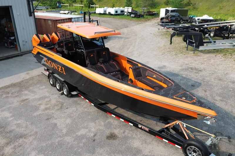 Slide: The Image of 2024 Donzi 39 VRZ powerboat in vibrant orange and black on a trailer. - 58