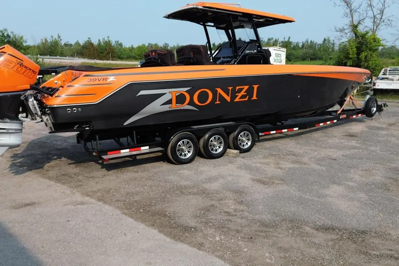 Slide: The Image of 2024 Donzi 39 VRZ boat with orange and black design on a trailer. - 63