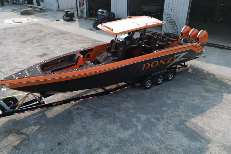 Slide: The Image of 2024 Donzi 39 VRZ boat with orange and black design on a trailer. - 66