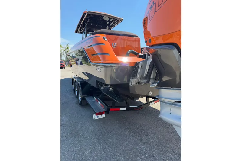 Slide: The Image of 2024 Donzi 39 VRZ boat on trailer, rear view, vibrant orange and black design. - 11