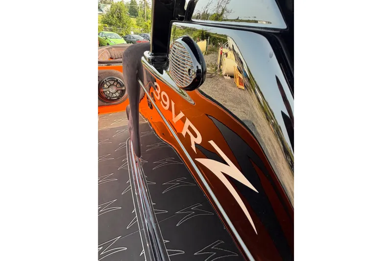 Slide: The Image of 2024 Donzi 39 VRZ boat with sleek black and orange design, close-up view. - 54
