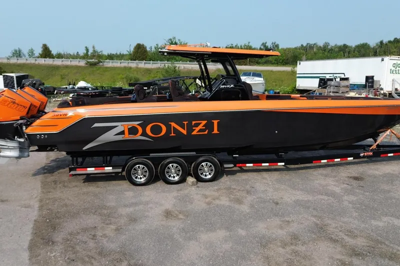 Slide: The Image of 2024 Donzi 39 VRZ powerboat in black and orange on a trailer, parked outdoors. - 62