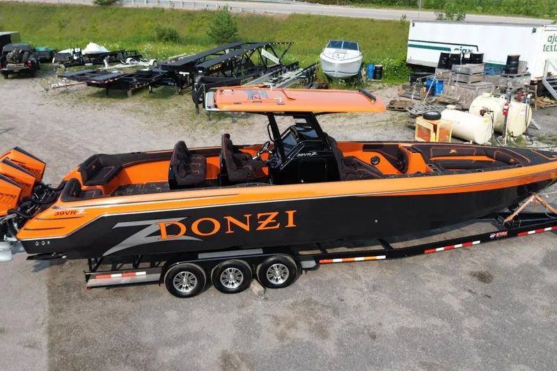 Slide: The Image of 2024 Donzi 39 VRZ powerboat with vibrant orange and black design on a trailer. - 61