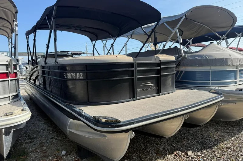 Slide: The Image of 2016 Bennington 2550 RBR pontoon boat with canopy, docked among other boats. - 15
