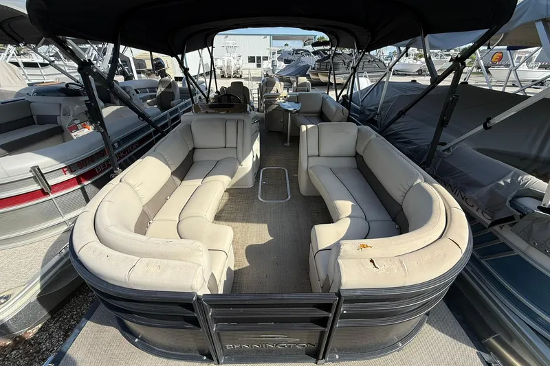 Slide: The Image of 2016 Bennington 2550 RBR pontoon boat with spacious seating and canopy, docked at marina. - 11