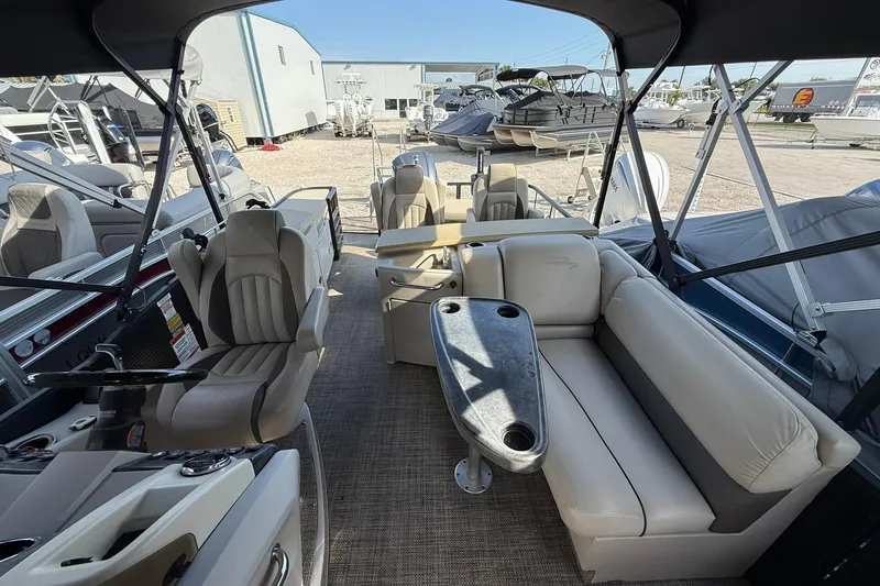 Slide: The Image of Interior of a 2016 Bennington 2550 RBR pontoon boat with beige seating and steering console. - 8