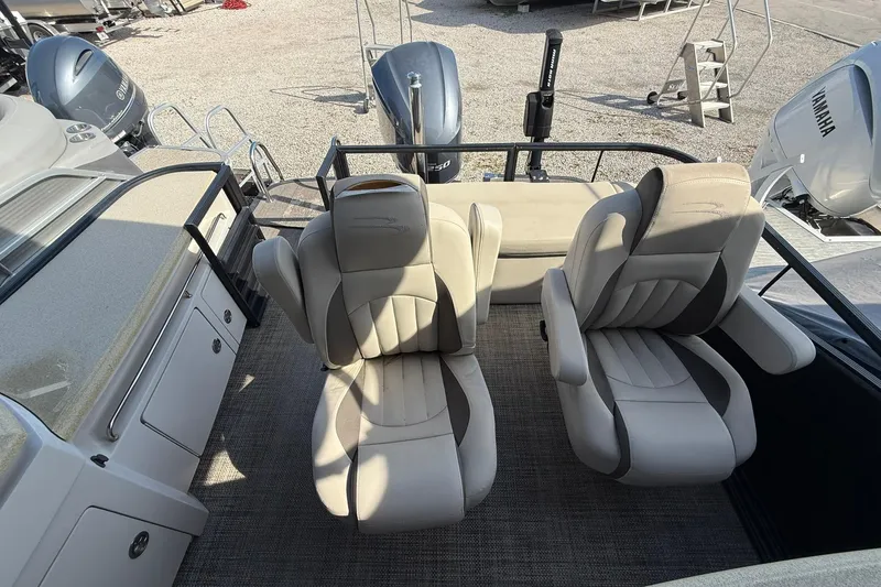 Slide: The Image of 2016 Bennington 2550 RBR boat interior with two plush captain chairs and Yamaha engines. - 5