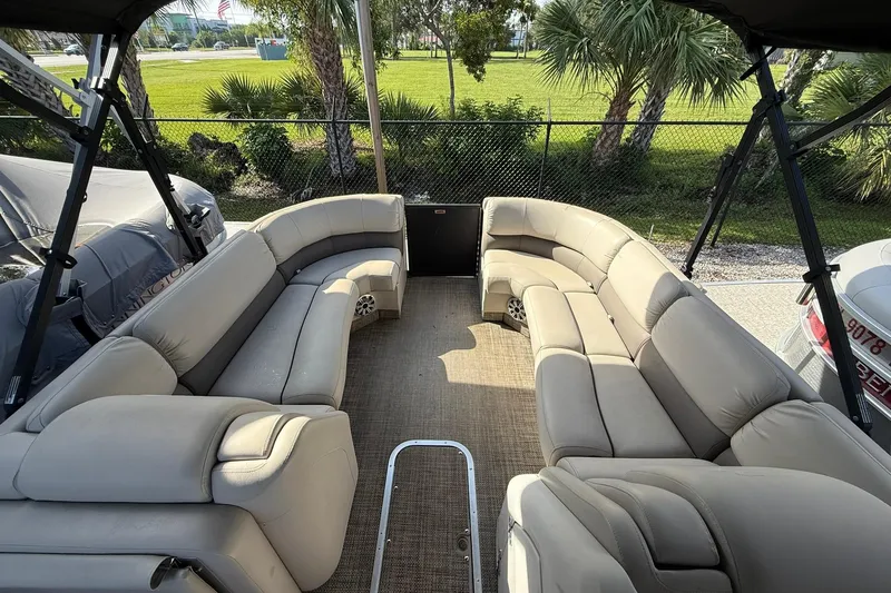 Slide: The Image of 2016 Bennington 2550 RBR pontoon boat with spacious beige seating and outdoor view. - 9