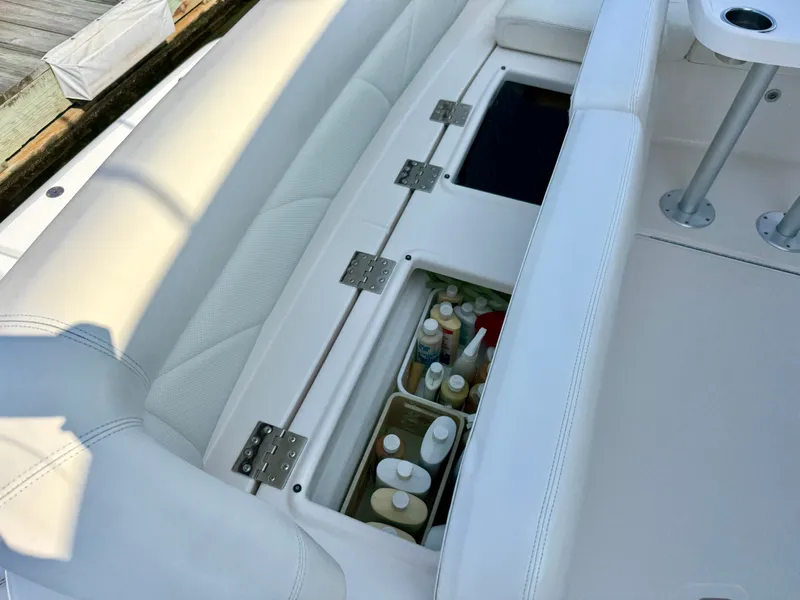 Slide: The Image of The 2006 Tiara Yachts 4300 Sovran features a bench seat with storage underneath, filled with bottles. - 13
