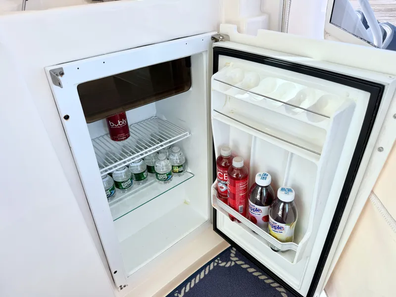 Slide: The Image of An open fridge on a yacht displays beverages like water bottles and juice bottles. - 26