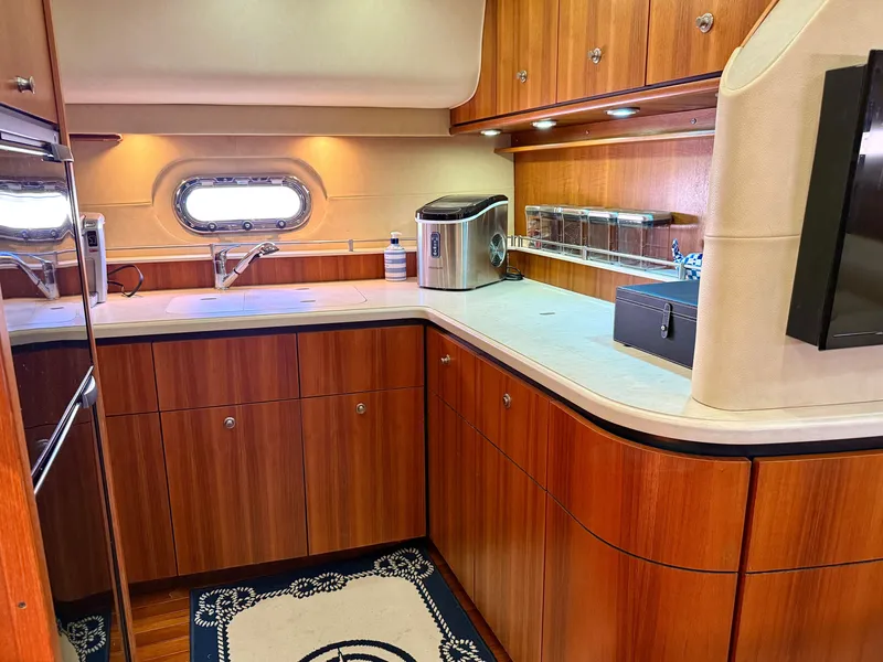 Slide: The Image of The 2006 Tiara Yachts 4300 Sovran's galley features elegant wood cabinetry and modern appliances. - 48
