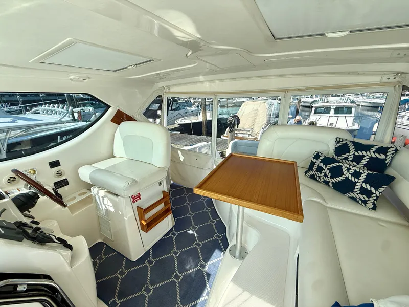 Slide: The Image of The interior of a 2006 Tiara Yachts 4300 Sovran features an elegant seating area with a wooden table. - 35