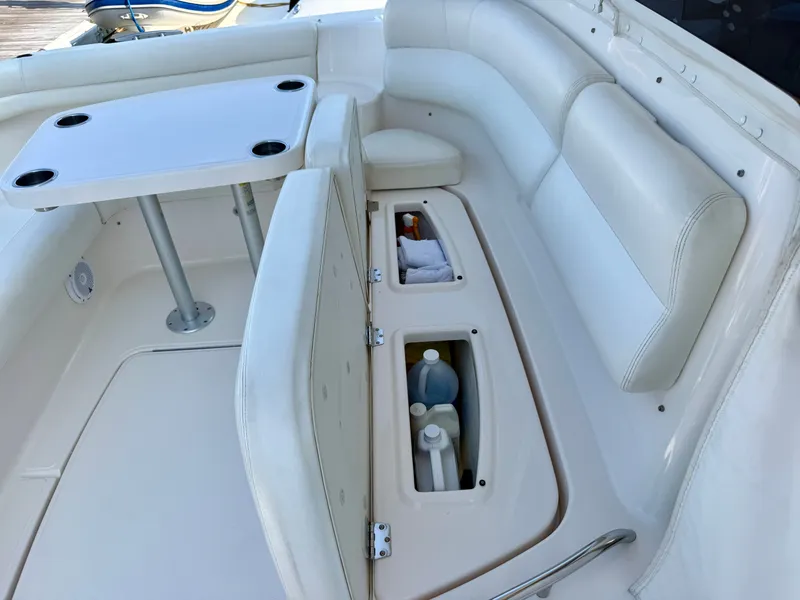 Slide: The Image of The image shows a white seating area with built-in storage and a table on a boat. - 14