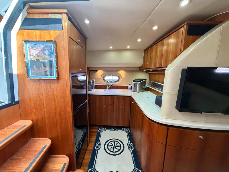 Slide: The Image of The interior of a 2006 Tiara Yachts 4300 Sovran features an elegant kitchen with wooden cabinets. - 41