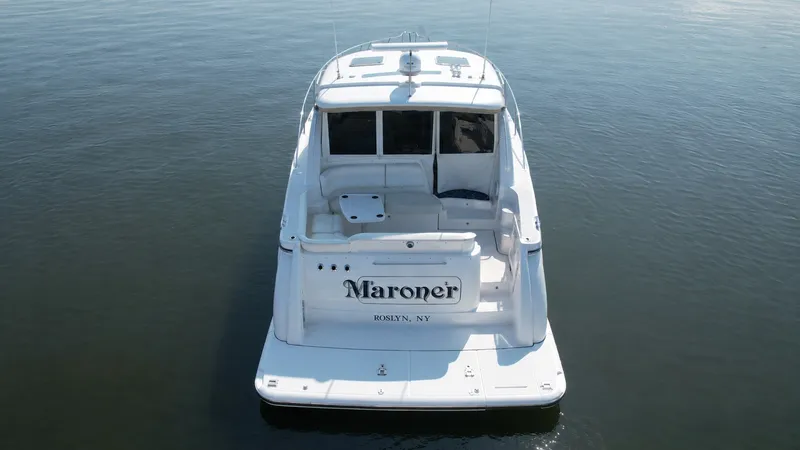 Slide: The Image of A 2006 Tiara Yachts 4300 Sovran on calm water. It features a spacious aft deck. - 4