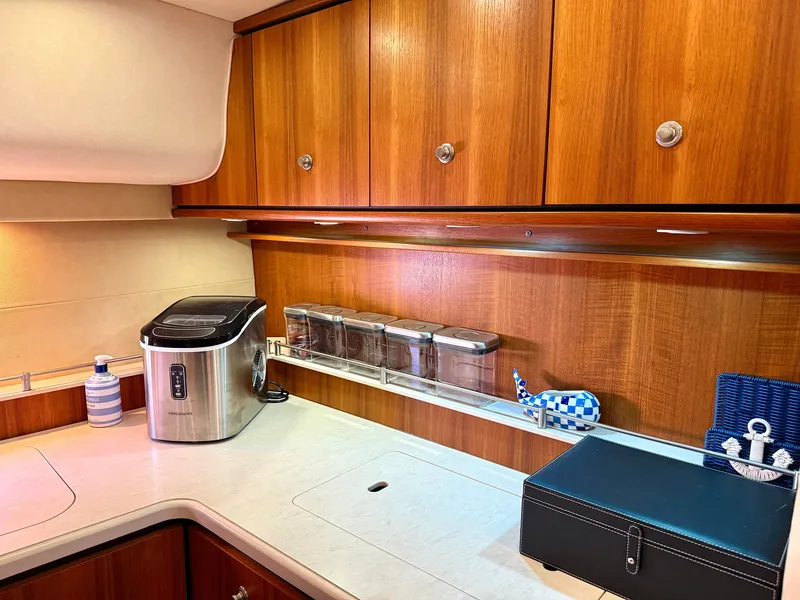 Slide: The Image of The galley of a 2006 Tiara Yachts 4300 Sovran with wooden cabinets and modern appliances. - 49