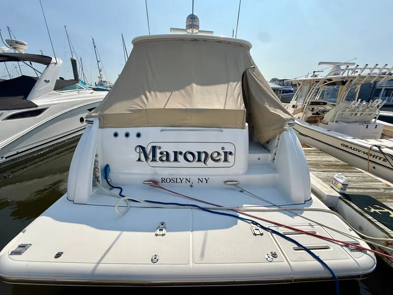 Slide: The Image of A 2006 Tiara Yachts 4300 Sovran docked at a marina, featuring a beige cover. - 6