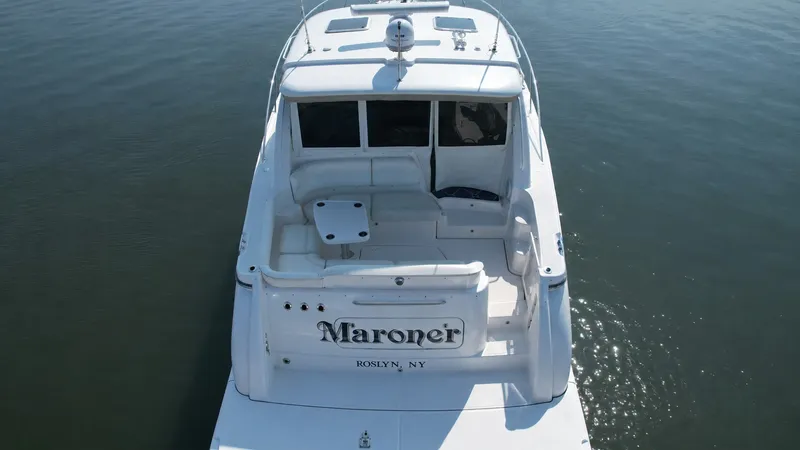 Slide: The Image of The 2006 Tiara Yachts 4300 Sovran sits calmly on the water, featuring a spacious cockpit. - 5
