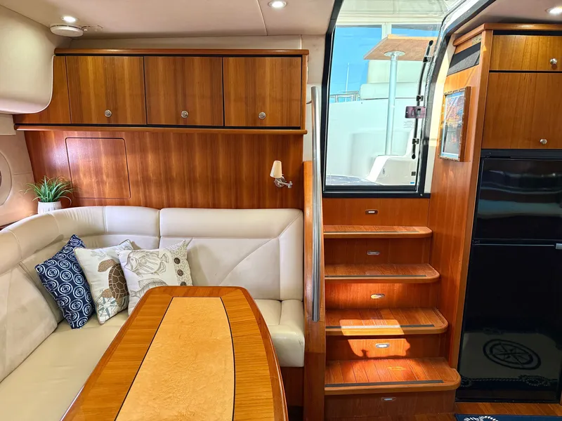 Slide: The Image of The 2006 Tiara Yachts 4300 Sovran interior features an elegant seating area with a wooden table. - 44