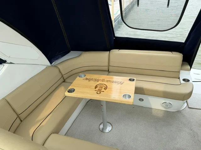 Slide: The Image of The image shows a beige leather seating area with a wooden table on a boat. - 9