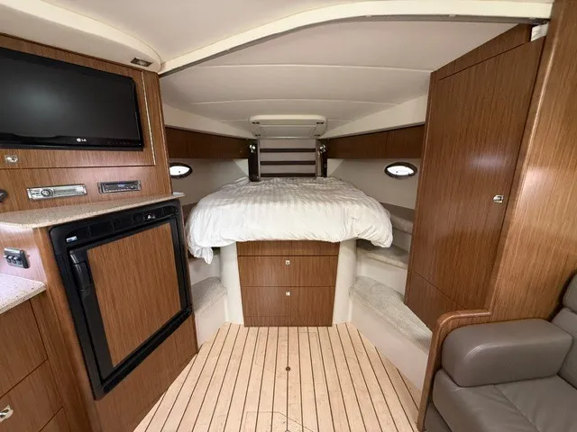 Slide: The Image of Interior of a 2013 Cruisers Yachts 380 Express with a cozy bed and wooden cabinetry. - 13