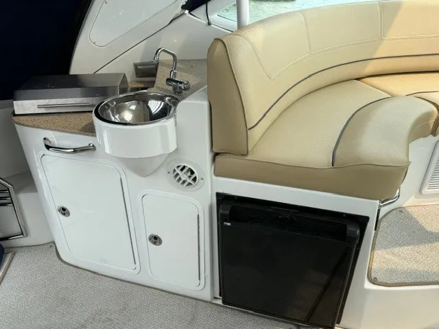 Slide: The Image of The interior of a 2013 Cruisers Yachts 380 Express features a small sink and seating area. - 7