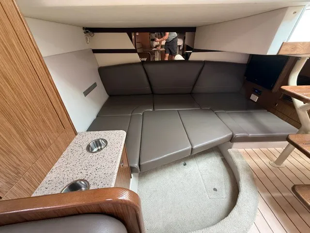 Slide: The Image of Interior of a 2013 Cruisers Yachts 380 Express with gray leather seating and wood accents. - 16