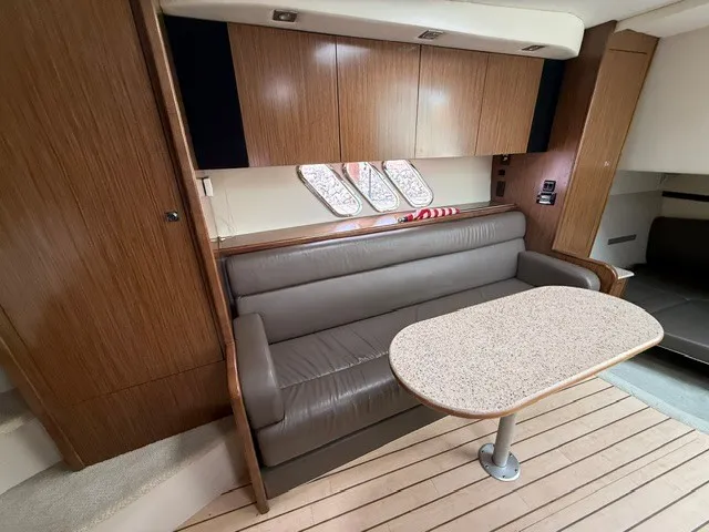 Slide: The Image of Interior of a 2013 Cruisers Yachts 380 Express featuring a sofa and table. - 14