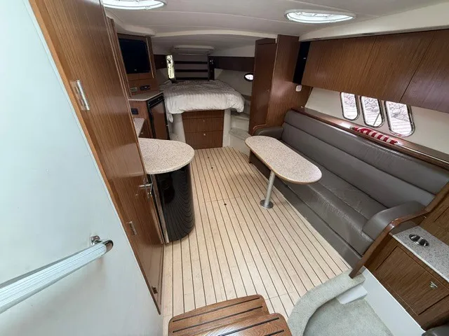 Slide: The Image of Interior of a 2013 Cruisers Yachts 380 Express with wood flooring, sofa, and sleeping area. - 19