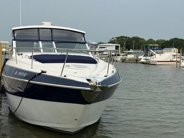 Slide: The Image of A 2013 Cruisers Yachts 380 Express docked in a marina. It features a sleek, modern design. - 2