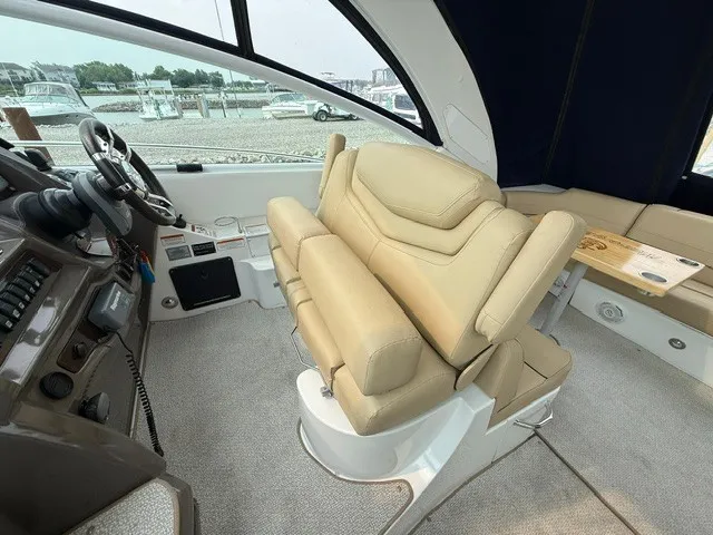 Slide: The Image of Interior of a 2013 Cruisers Yachts 380 Express with beige leather seating and helm console. - 10