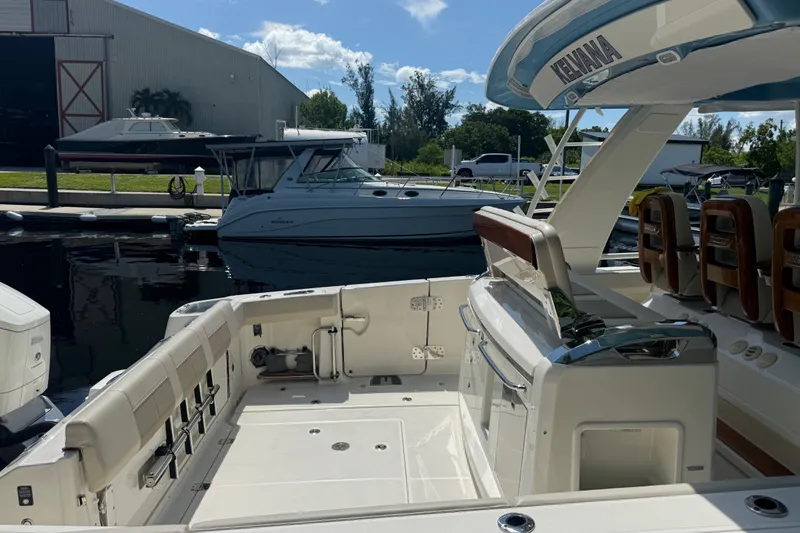 Slide: The Image of 2024 Boston Whaler 420 Outrage boat interior at marina, showcasing seating and helm area. - 50