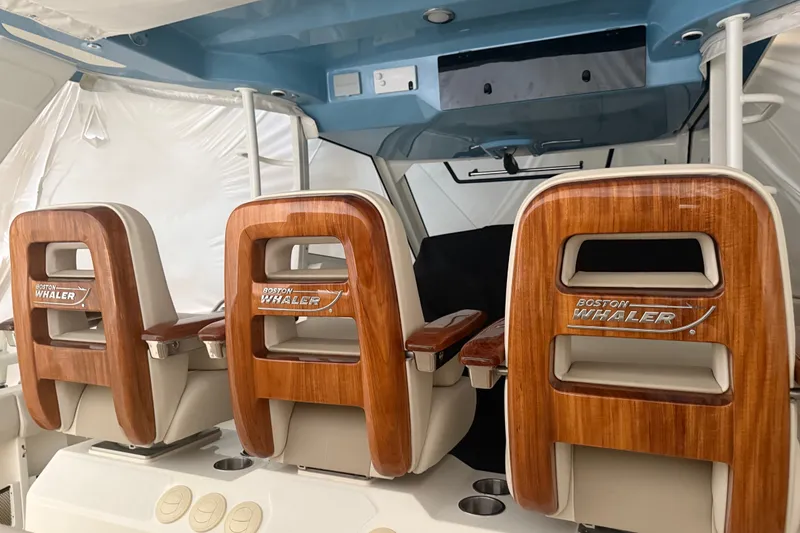 Slide: The Image of 2024 Boston Whaler 420 Outrage interior with elegant wooden seating. - 14
