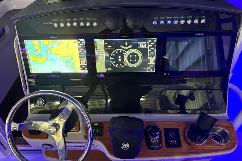 Slide: The Image of 2024 Boston Whaler 420 Outrage dashboard with navigation screens and steering wheel. - 12