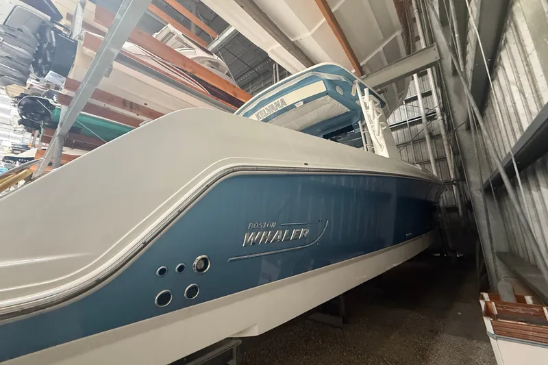 Slide: The Image of 2024 Boston Whaler 420 Outrage boat in storage, showcasing sleek blue and white design. - 28
