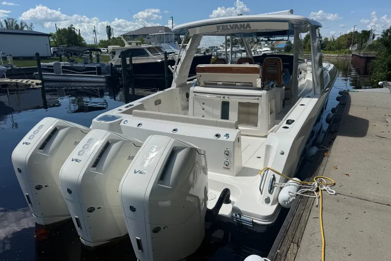 Slide: The Image of 2024 Boston Whaler 420 Outrage docked, featuring triple Mercury 600 V12 engines. - 2