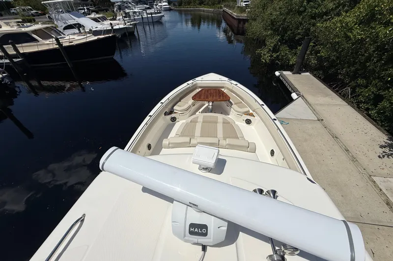 Slide: The Image of 2024 Boston Whaler 420 Outrage docked, showcasing spacious deck and seating area. - 68