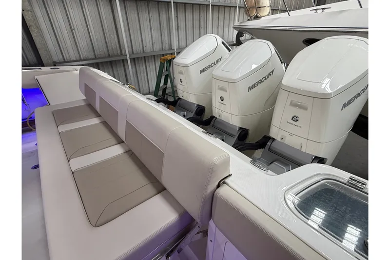 Slide: The Image of 2024 Boston Whaler 420 Outrage with triple Mercury Verado engines and luxurious seating. - 16
