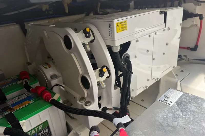Slide: The Image of Engine compartment of 2024 Boston Whaler 420 Outrage, showcasing battery and wiring components. - 57