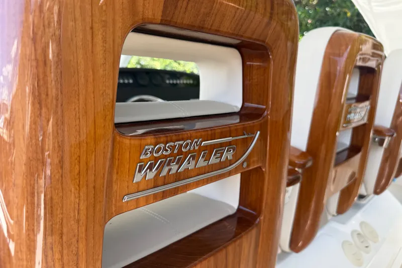 Slide: The Image of 2024 Boston Whaler 420 Outrage interior with polished wood accents and logo detail. - 72