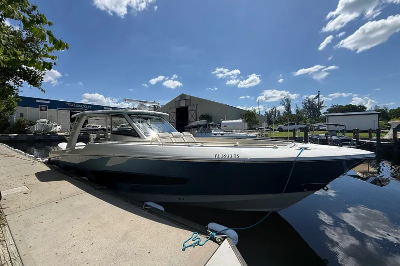 Slide: The Image of 2024 Boston Whaler 420 Outrage docked under a clear blue sky. - 1