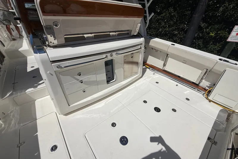 Slide: The Image of 2024 Boston Whaler 420 Outrage deck with storage compartments and sleek design. - 41