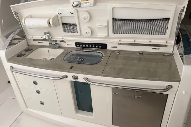 Slide: The Image of 2024 Boston Whaler 420 Outrage boat kitchen with sink, storage, and countertop. - 22