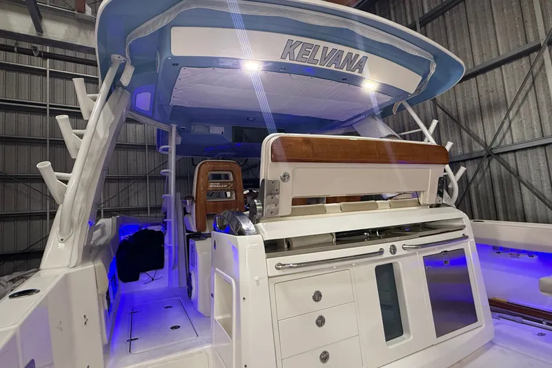Slide: The Image of 2024 Boston Whaler 420 Outrage boat interior with blue LED lighting in a storage facility. - 10