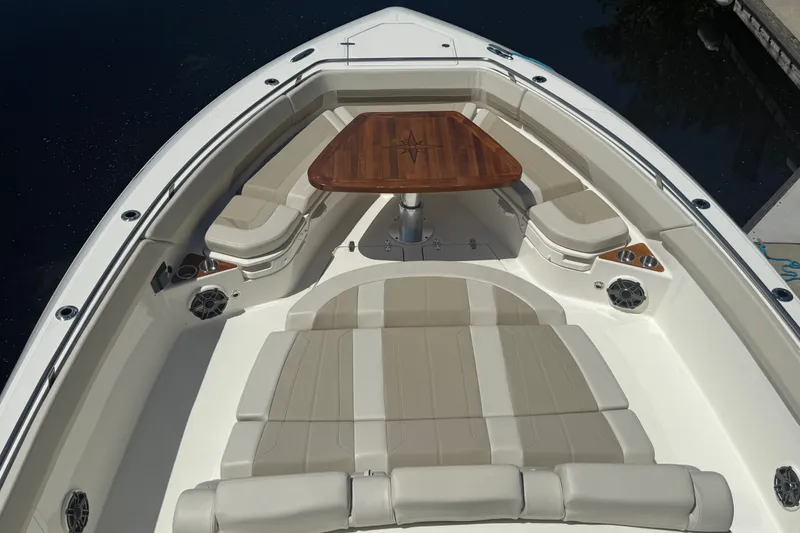 Slide: The Image of 2024 Boston Whaler 420 Outrage boat interior with seating and wooden table. - 67