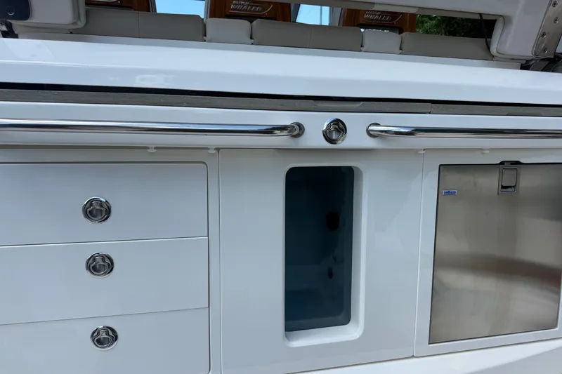 Slide: The Image of 2024 Boston Whaler 420 Outrage boat interior with storage compartments and stainless steel accents. - 55