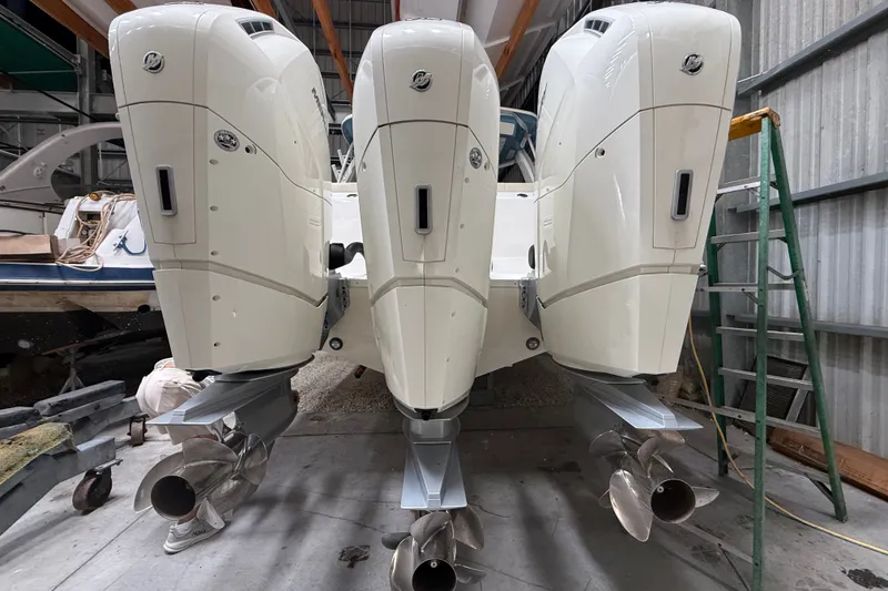 Slide: The Image of 2024 Boston Whaler 420 Outrage with triple outboard engines in a storage facility. - 3