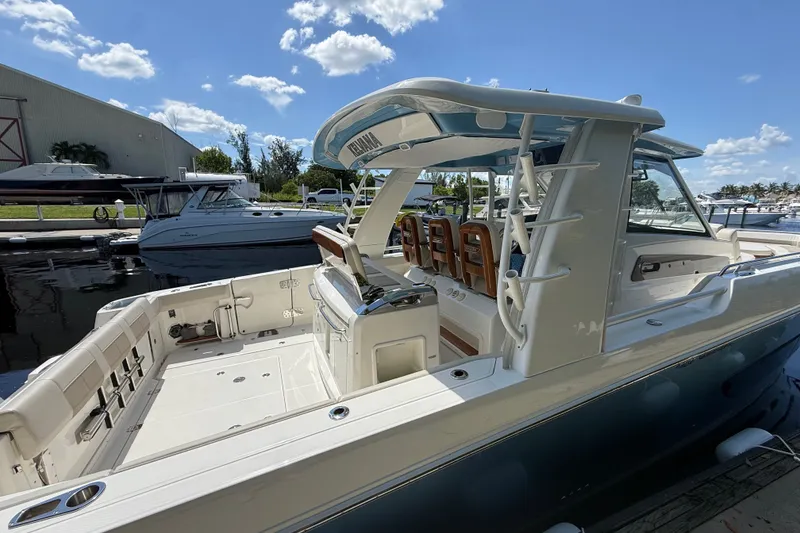 Slide: The Image of 2024 Boston Whaler 420 Outrage boat docked under a clear blue sky. - 5