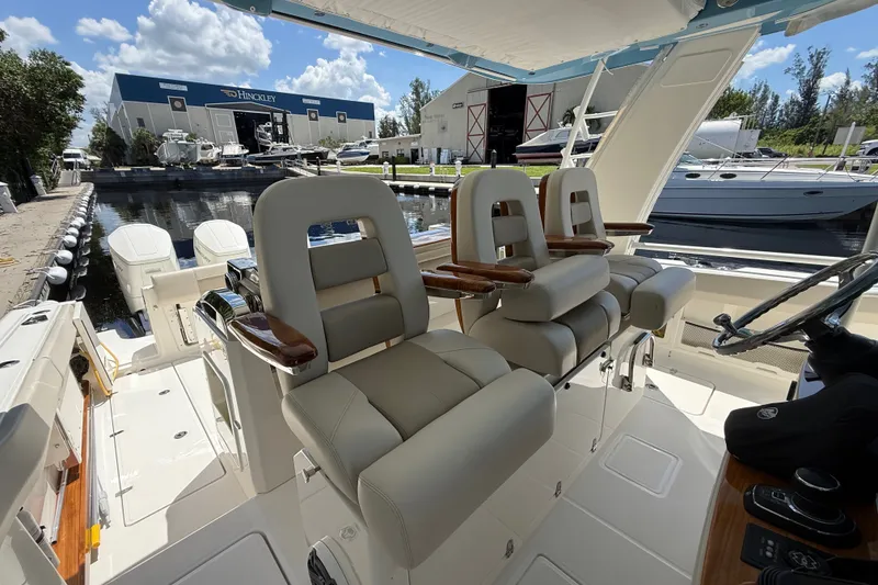 Slide: The Image of 2024 Boston Whaler 420 Outrage helm seats with luxurious design at marina. - 81